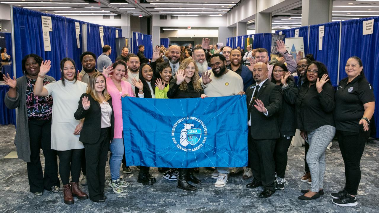 CISA employees at event holding flag.